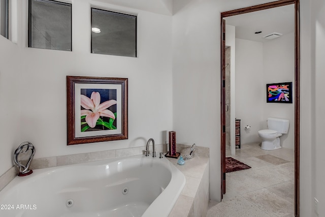 bathroom featuring toilet, tile patterned flooring, and tiled bath