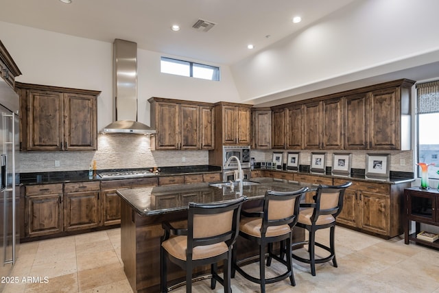 9216 E Sky Line Dr, Scottsdale, AZ 85262 - kitchen with wall chimney range hood, a sink, decorative backsplash, a center island with sink, and gas stovetop