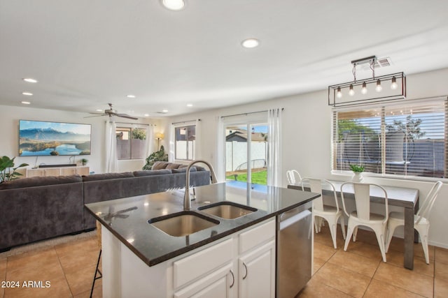 kitchen with white cabinets, a kitchen island with sink, pendant lighting, sink, and stainless steel dishwasher