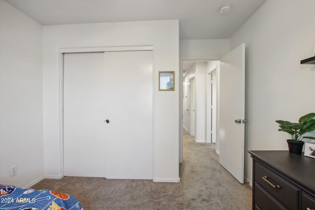 bedroom featuring a closet and light colored carpet