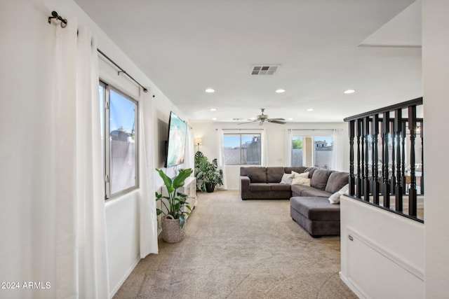 living room featuring light colored carpet and ceiling fan