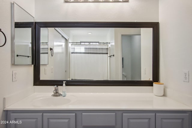 bathroom with toilet, curtained shower, and vanity