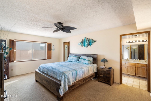 bedroom featuring ensuite bath, ceiling fan, sink, a textured ceiling, and light carpet