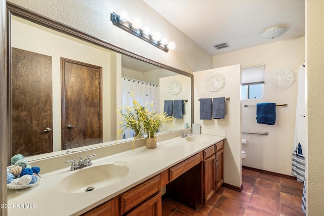 bathroom with tile patterned flooring, vanity, and toilet