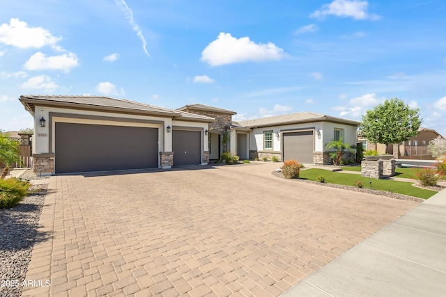 5415 E Chaparosa Way, Cave Creek, AZ 85331 - prairie-style house with stone siding, decorative driveway, an attached garage, stucco siding, and a front yard