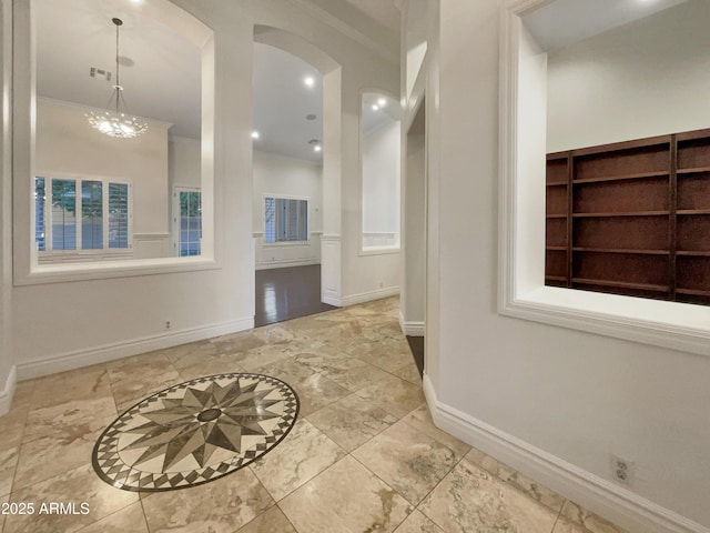 entrance foyer featuring an inviting chandelier and ornamental molding