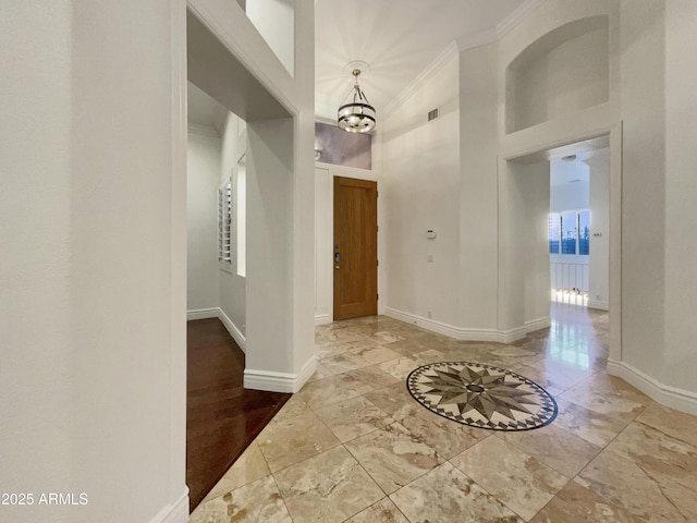 entrance foyer featuring an inviting chandelier, ornamental molding, and a high ceiling