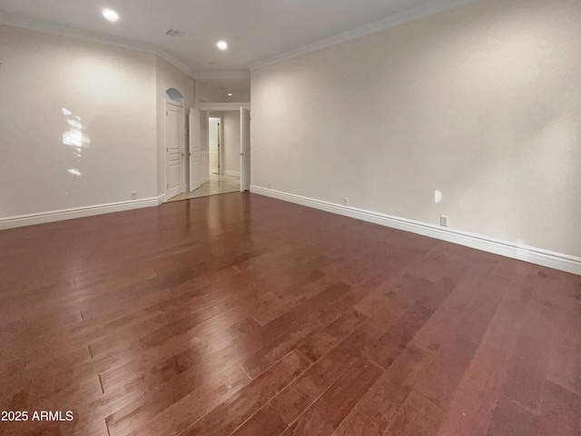 empty room featuring dark hardwood / wood-style flooring and ornamental molding