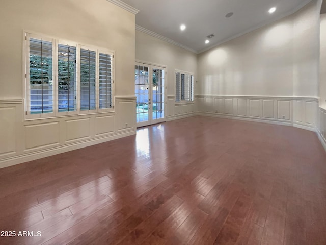 empty room with crown molding, hardwood / wood-style floors, and french doors