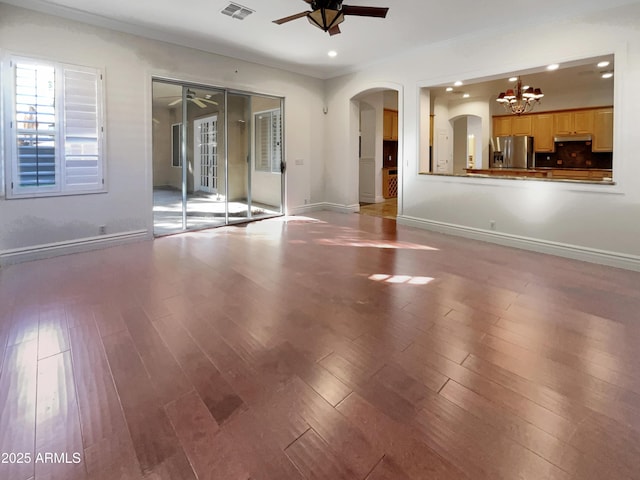 unfurnished room featuring ceiling fan with notable chandelier, ornamental molding, and light wood-type flooring