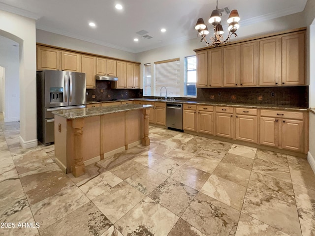 kitchen featuring pendant lighting, crown molding, appliances with stainless steel finishes, dark stone countertops, and a kitchen island