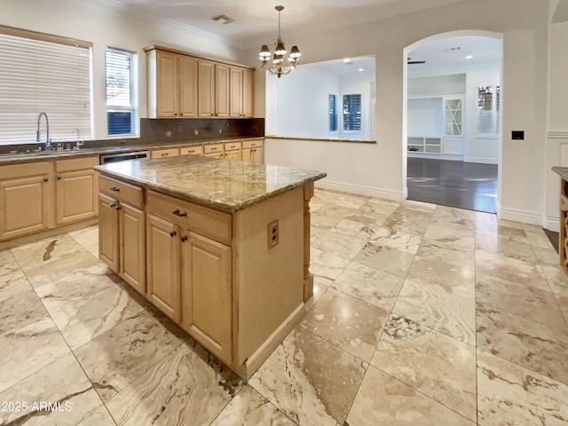 kitchen featuring sink, stone counters, a kitchen island, decorative light fixtures, and light brown cabinets