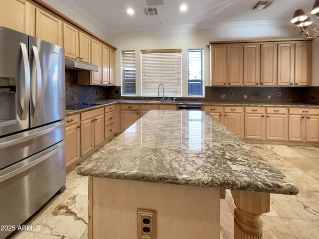 kitchen with stainless steel appliances, a kitchen island, light brown cabinets, and stone counters