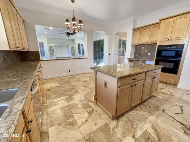 kitchen with crown molding, a center island, light brown cabinets, light stone countertops, and decorative backsplash