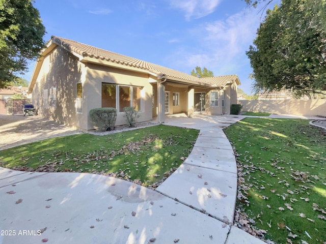 mediterranean / spanish-style home featuring a patio area and a front lawn