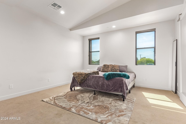 bedroom featuring multiple windows, light colored carpet, and vaulted ceiling