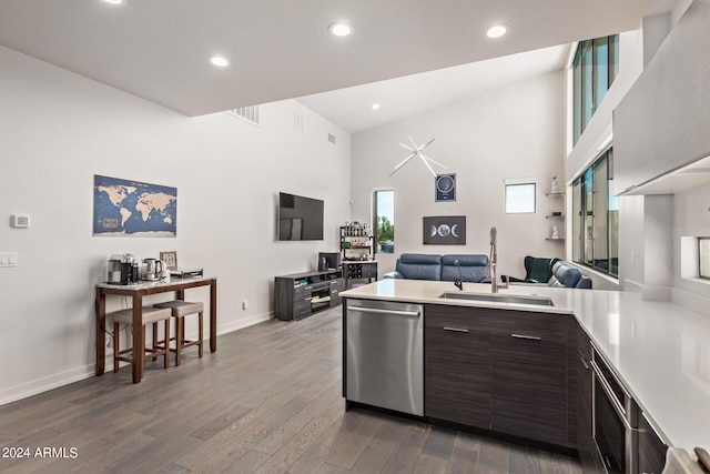 kitchen featuring dishwasher, hardwood / wood-style floors, sink, dark brown cabinets, and high vaulted ceiling