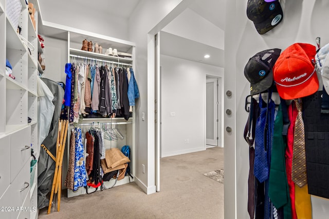 walk in closet with light colored carpet