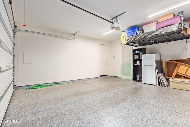 garage with white refrigerator and a garage door opener