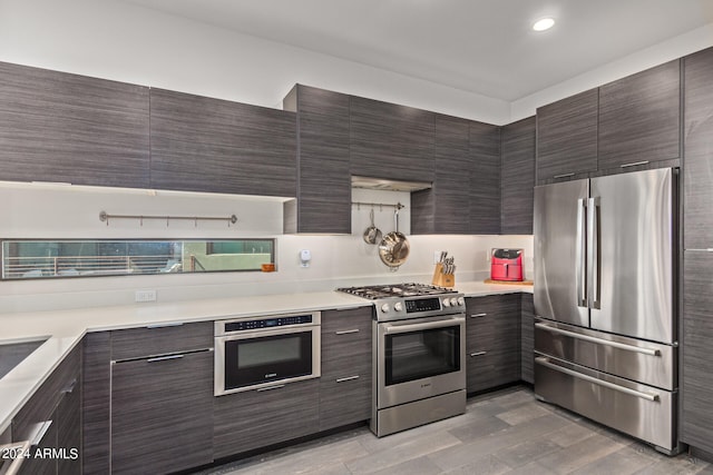 kitchen with appliances with stainless steel finishes and light hardwood / wood-style floors