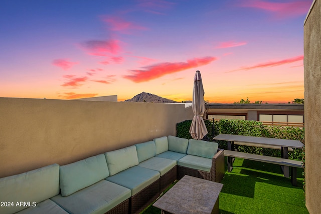 patio terrace at dusk featuring a mountain view, a lawn, and outdoor lounge area