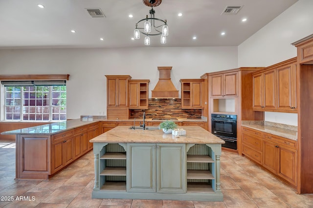 1925 W Tanya Trl, Phoenix, AZ 85086 - kitchen featuring open shelves, oven, custom range hood, a center island with sink, and tasteful backsplash