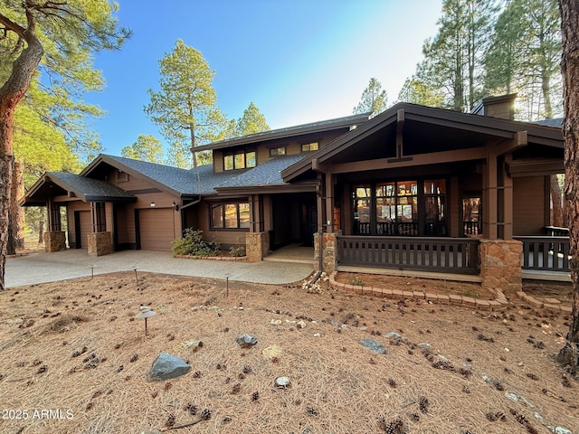 view of front facade with covered porch, a garage, and concrete driveway