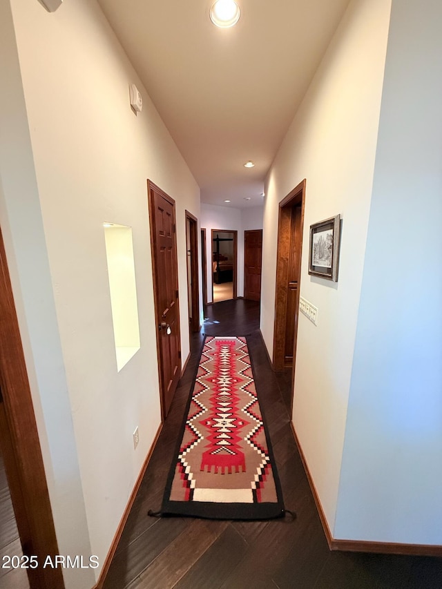 hallway featuring baseboards, recessed lighting, and dark wood-style flooring