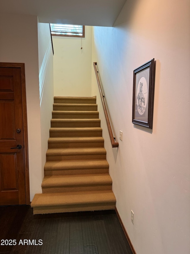 stairway with baseboards and wood finished floors