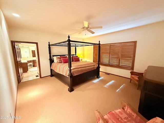 bedroom with visible vents, ensuite bath, light colored carpet, and recessed lighting