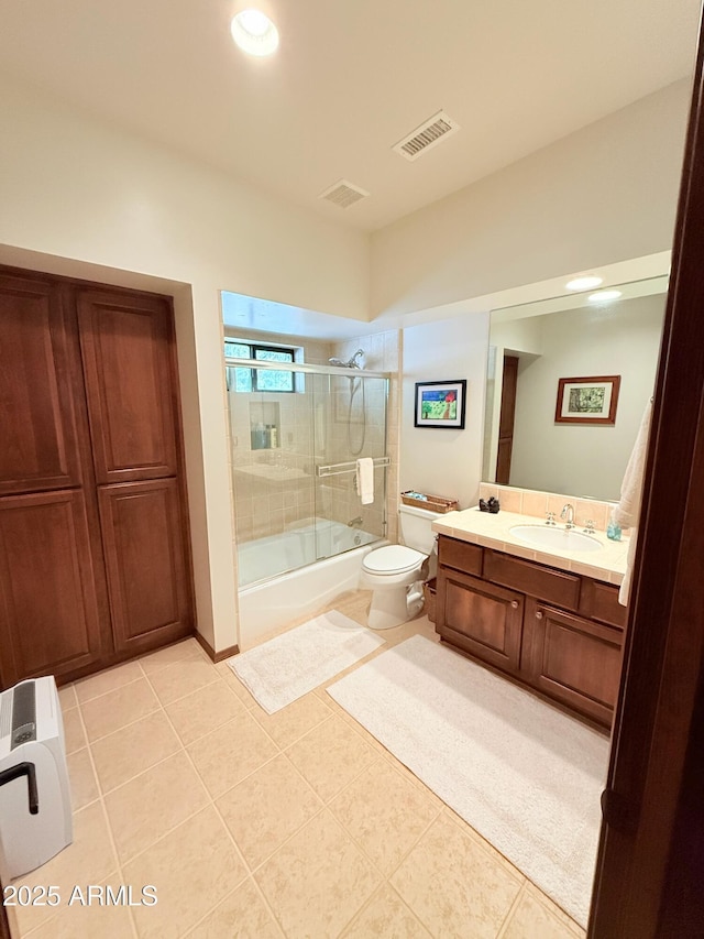 bathroom with toilet, vanity, enclosed tub / shower combo, and visible vents
