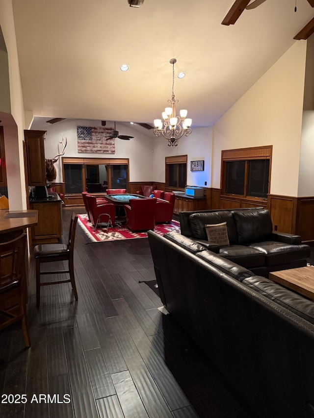 living room featuring a wainscoted wall, vaulted ceiling, ceiling fan with notable chandelier, and billiards