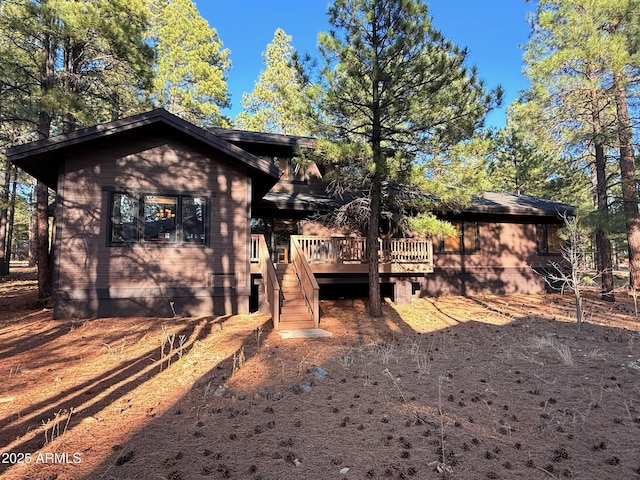 rear view of property featuring crawl space, stairs, and a wooden deck