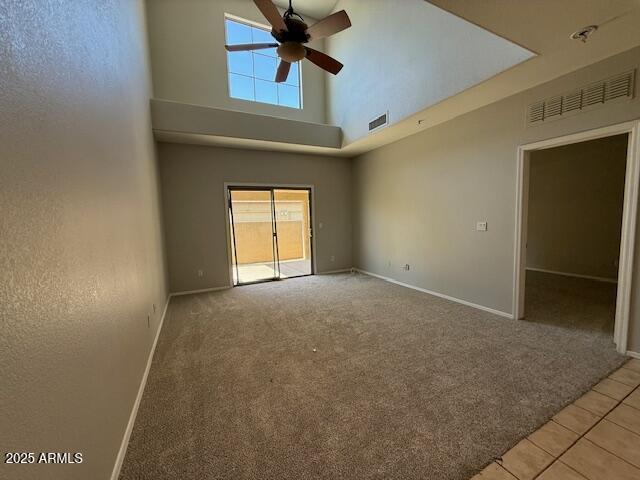 15655 N 29th St, Phoenix, AZ 85032 - empty room featuring light carpet, healthy amount of natural light, ceiling fan, a high ceiling, and light tile patterned flooring