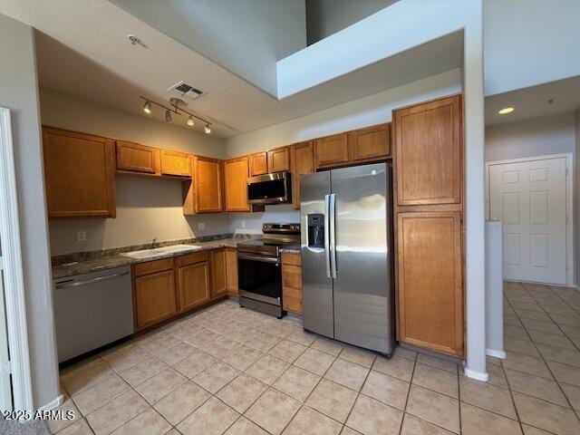 15655 N 29th St, Phoenix, AZ 85032 - kitchen featuring appliances with stainless steel finishes, light tile patterned floors, brown cabinetry, and dark countertops