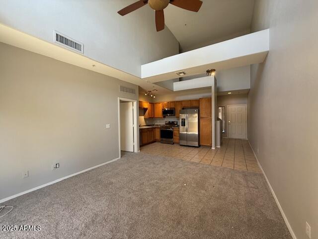 15655 N 29th St, Phoenix, AZ 85032 - unfurnished living room with light carpet, a ceiling fan, and a towering ceiling