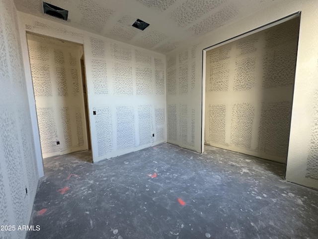 unfurnished bedroom with unfinished concrete flooring