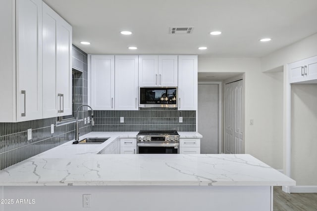 1003 E Princeton Ave, Gilbert, AZ 85234 - kitchen featuring stainless steel appliances, light stone countertops, tasteful backsplash, white cabinetry, and recessed lighting
