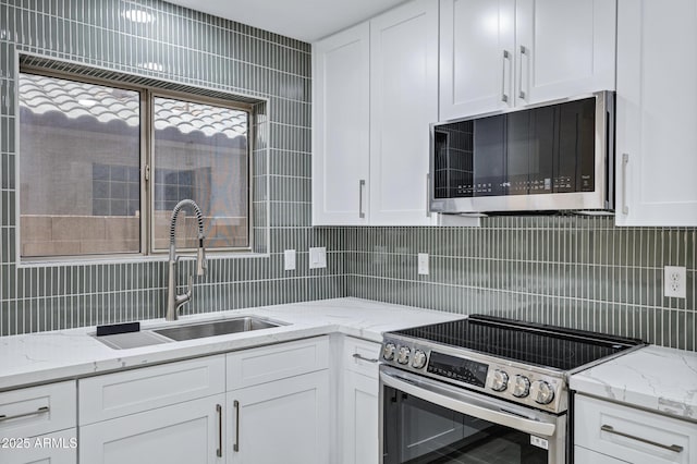 1003 E Princeton Ave, Gilbert, AZ 85234 - kitchen featuring stainless steel electric range oven, decorative backsplash, white cabinets, and light stone counters