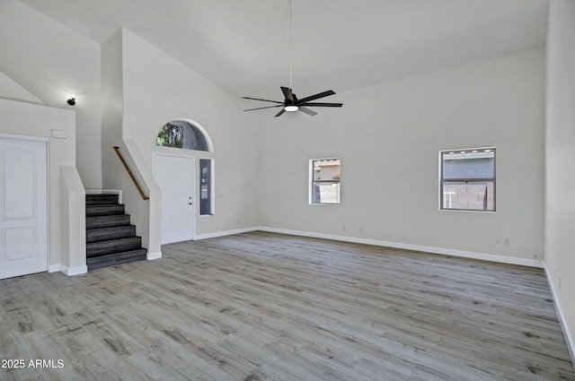 1003 E Princeton Ave, Gilbert, AZ 85234 - unfurnished living room featuring plenty of natural light, stairway, a ceiling fan, wood finished floors, and high vaulted ceiling