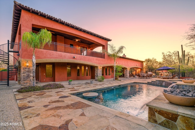 pool at dusk with a patio