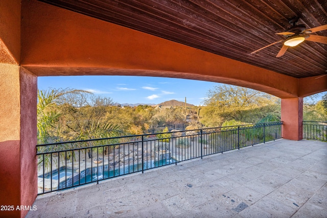 view of patio / terrace with a fenced in pool, ceiling fan, and a mountain view