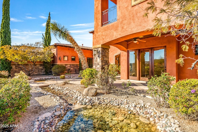 rear view of property with ceiling fan