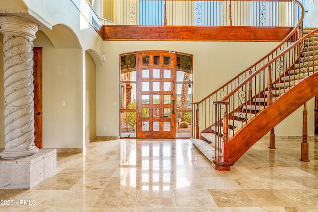 foyer entrance featuring ornate columns and a high ceiling