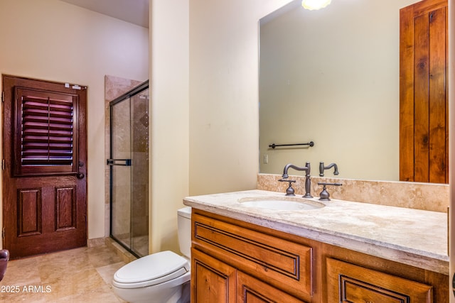 bathroom with vanity, toilet, and a shower with door