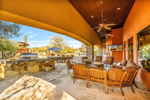 view of patio / terrace featuring area for grilling, an outdoor hangout area, an outdoor bar, and ceiling fan