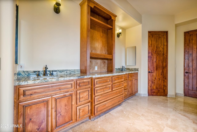 interior space with light stone countertops and sink