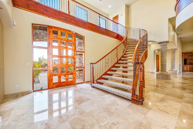 entrance foyer with ornate columns and a high ceiling