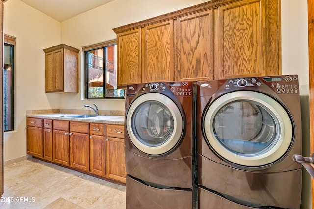 clothes washing area with sink, cabinets, and washing machine and clothes dryer