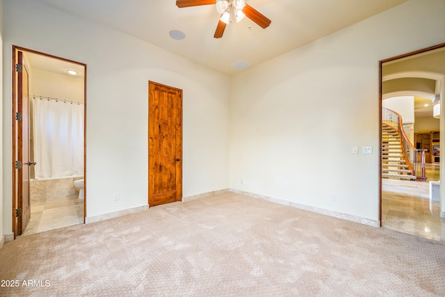 spare room with ceiling fan and light colored carpet